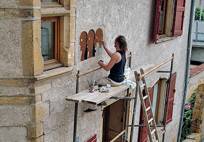 Le peintre Chudo restaurant une ancienne enseigne des Trois Maures à l'Arbresle (détail d'une cliché du photographe professionnel Régis Moissonnier, © Chudo et Régis Moissonnier)